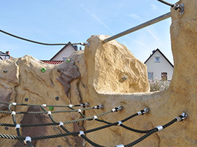 artificial climbing rocks with net in playground 